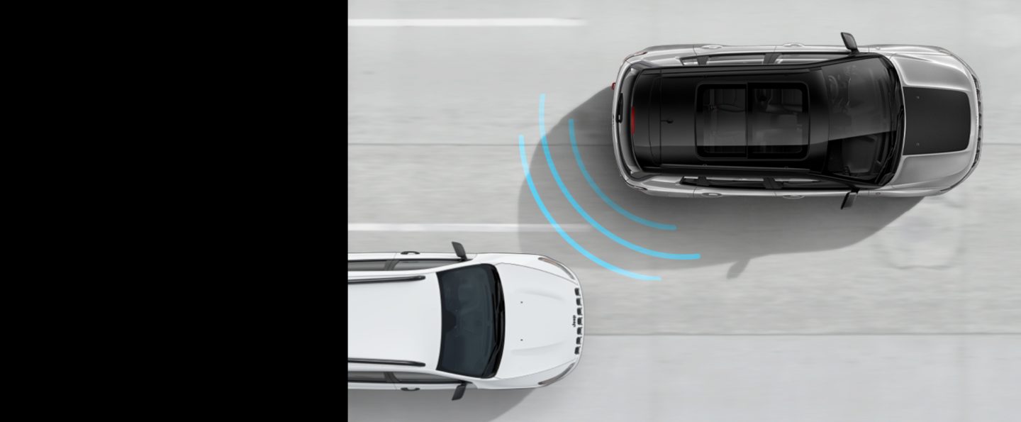An illustration of sensors in the rear of the 2020 Jeep Compass detecting a vehicle in its blind spot.