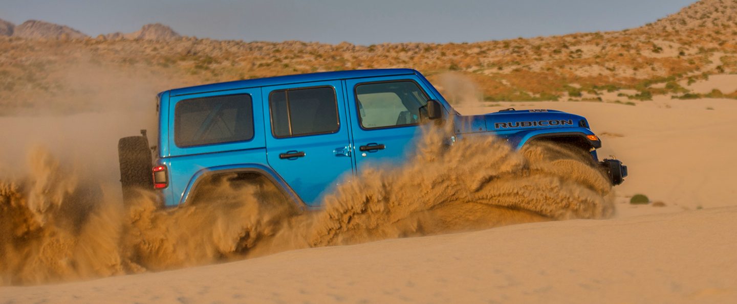 The 2021 Jeep Wrangler Rubicon 392 plowing through deep sand.