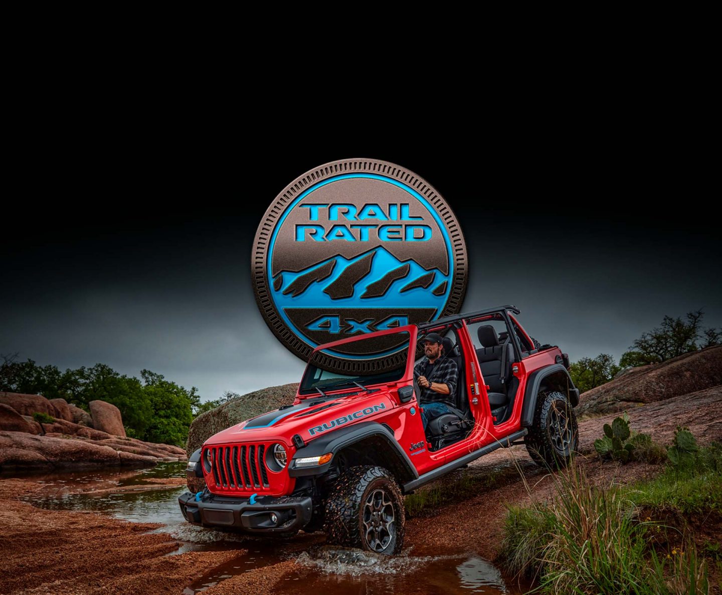 The Trail Rated 4x4 logo positioned above a 2022 Jeep Wrangler Rubicon 4xe with its doors and roof off as it descends a hill.